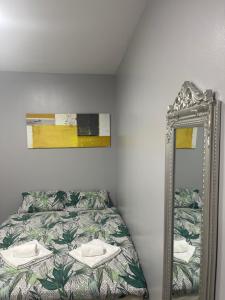 a bedroom with a bed and a mirror at Grays Accommodation B&B in Grays Thurrock