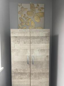 um armário de madeira com uma pintura na parede em Grays Accommodation B&B em Grays Thurrock