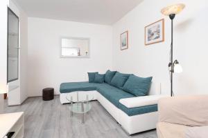 sala de estar blanca con sofá azul en Apartment Filip, en Hvar