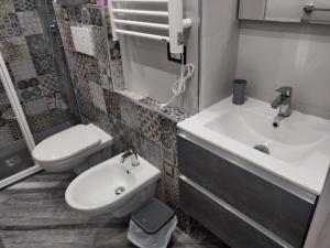 uma casa de banho com um lavatório, um WC e um lavatório. em Appartamento in Piazza Vittorio Veneto con parcheggio, Torino em Turim