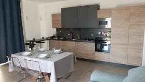 a kitchen with a table with chairs and a dining room at Villetta vicino al mare in Porto Palo