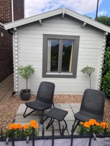 two chairs and flowers in front of a house at Nancy's Cabin in Mosborough +17 photos