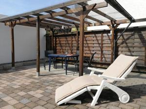 un patio con silla, mesa y toldo en Abendsonne Apartments, en Coblenza
