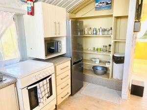 a kitchen with a stove and a refrigerator at Top beach studio in Herolds Bay