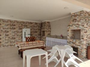 a living room with white chairs and a brick wall at Recanto da Ivete in São Sebastião