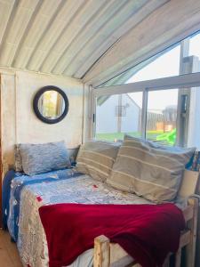 a bed in a room with a large window at Top beach studio in Herolds Bay