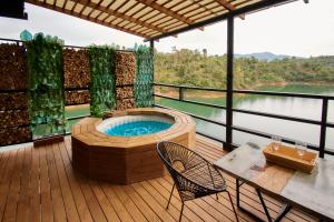 a hot tub on a deck with a table and chairs at Hotel Mumu Guatapé in Guatapé
