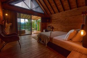 una camera da letto con un letto e una grande finestra di Mumu by Bernalo Hotels a Guatapé