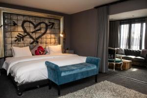 a bedroom with a large bed with a heart on the wall at The Exhibitionist Hotel in London