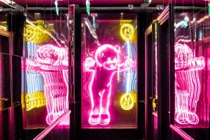 un gruppo di insegne al neon in una stanza di The Exhibitionist Hotel a Londra