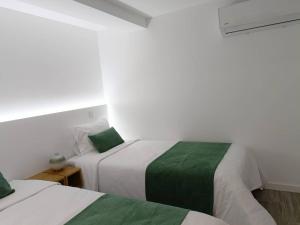 um quarto com 2 camas com lençóis verdes e brancos em AndreiHouse em Amares
