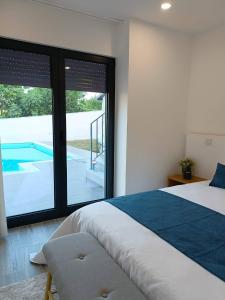 a bedroom with a bed and a view of a pool at AndreiHouse in Amares
