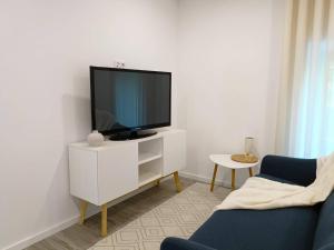 a living room with a tv on a white cabinet at AndreiHouse in Amares