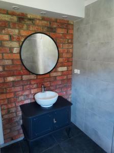 a bathroom with a sink and a mirror on a brick wall at Warmińska Przystań - dom całoroczny in Blanki +29 photos