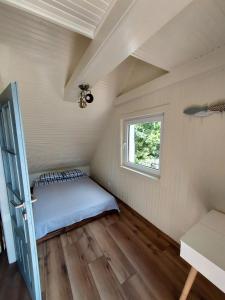 a bedroom in a tiny house with a bed at Warmińska Przystań - dom całoroczny in Blanki