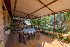 eine Außenterrasse mit einem Tisch und Stühlen in der Unterkunft Hemdatya Stone Suites In The Galilee in Ilaniyya