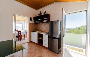 a kitchen with a stainless steel refrigerator and a balcony at Pet Friendly Home In Stratincica With Wifi in Vela Luka