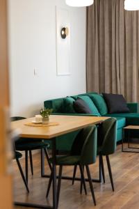 a living room with a table and a green couch at Apartamenty Termalne Dobry Klimat in Uniejow