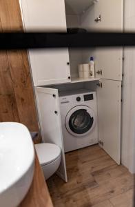 a bathroom with a washing machine and a toilet at Apartamenty Termalne Dobry Klimat in Uniejow