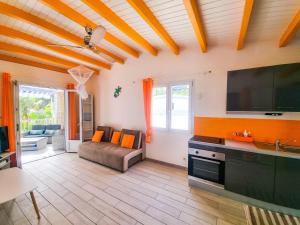 a living room with a television and a couch at Blue Paradise in Le Gosier