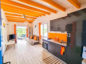 a kitchen with an orange ceiling and a living room at Blue Paradise in Le Gosier