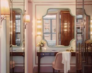 a bathroom with a vanity and two mirrors at Hotel Barrière Fouquet's New York in New York