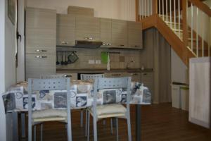 kuchnia ze stołem i krzesłami oraz schody w obiekcie A casa di Giò w mieście Loreto