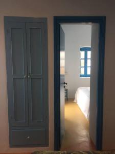 a room with a door and a bedroom with a bed at Traumhaus Nisyros in Páloi