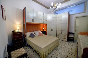Un dormitorio con una cama grande y una lámpara de araña. en Casa Vacanze Borgata del Sorbo, en Acireale
