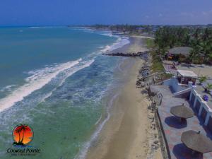 an aerial view of a beach with umbrellas and the ocean at Coconut Pointe Villa & Beach Resort in Prampram