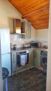 a kitchen with a white refrigerator and a dishwasher at The Rocks in Westward Ho