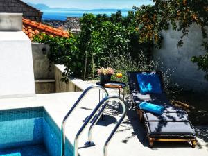 una silla junto a una piscina al lado de una casa en Villa Azzuro, en Selca