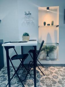 einen Tisch und zwei Stühle in einem Zimmer mit Pflanzen in der Unterkunft Bodegas de Felicidad in Setenil de las Bodegas