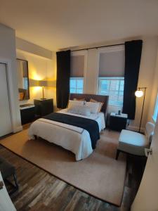 a bedroom with a large bed and two windows at Inner Harbor's Best Furnished Luxury Apartments apts in Baltimore