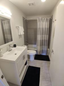 Inner Harbor's Best Furnished Luxury Apartments apts في بالتيمور: حمام مع حوض أبيض ومرحاض