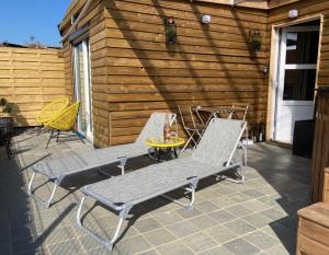 two chairs and a table on a patio at L'Eddy lodge in Neufchâteau