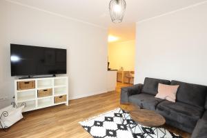 een woonkamer met een bank en een flatscreen-tv bij Apartments Vreden Familie Lansing in Vreden