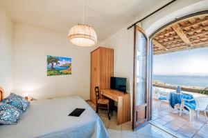 a bedroom with a bed and a desk and a table at POOL APPARTAMENT in Ischia