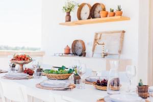 a dining room table with plates and bowls of fruit at Masseria Macchiaforte in Gallipoli