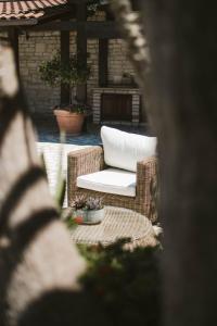 a wicker chair with a white pillow on a patio at Villa Pietra Bianca - Luxury stay in Puglia in Trani