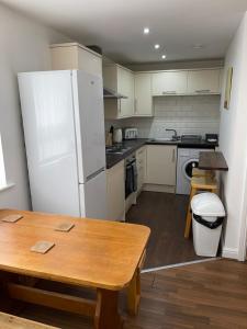 kuchnia z białą lodówką i drewnianym stołem w obiekcie Quiet 5 bed apartment in Liverpool w Liverpoolu