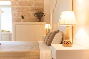 a bedroom with a bed with a lamp on a table at Masseria Macchiaforte in Gallipoli