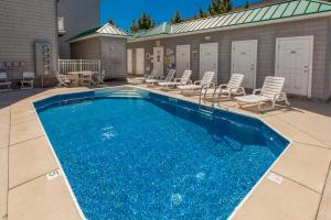 a swimming pool with chairs and a table at Dolphin's Run 204 DSS in Virginia Beach
