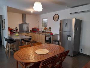 eine Küche mit einem Holztisch und einem Kühlschrank in der Unterkunft Le Hameau de Bagatelle - Etablissement Touristique in Bagatelle