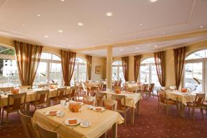 a dining room with tables and chairs and windows at Landhaus Bergkrone in Willingen
