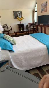 a bedroom with a large white bed with blue pillows at Hotel Marina Azul in Viña del Mar