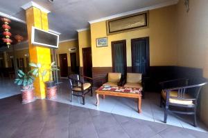 een lobby met een bank en een tafel en stoelen bij SPOT ON 3605 Clarichie Guest House in Kupang