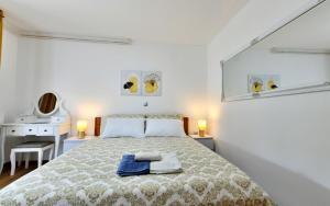 ein weißes Schlafzimmer mit einem Bett und einem Schreibtisch in der Unterkunft Apartmani Brium in Rakovica