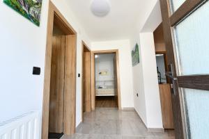 a hallway with white walls and a wooden door at Apartmani Brium in Rakovica
