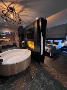 een grote badkamer met een groot bad en een bed bij Brabant Suites in Nistelrode